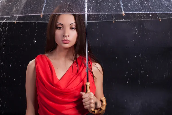 Fille dans une robe rouge sous la pluie — Photo