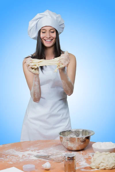 Sexy girl wearing chef prepares dough. — Stock Photo, Image