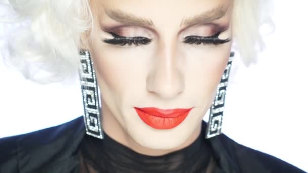 Крупным планом лицо пародийной блондинки с красными губами, голубыми глазами и броским макияжем — стоковое видео