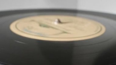 extreme close-up, detailed. Old phonograph needle on a spinning vinyl record