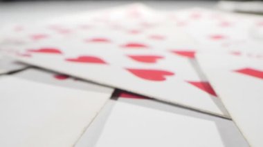extremely close-up detailed, randomly lying playing cards of the red suit of hearts and diamonds