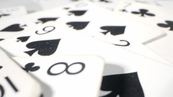 Extremely close-up detailed shot of playing cards suits of spades and clubs lying randomly on the table — Vídeos de Stock