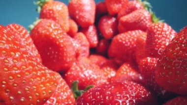 food background. extremely close up detailed bunch of strawberries on a blue background
