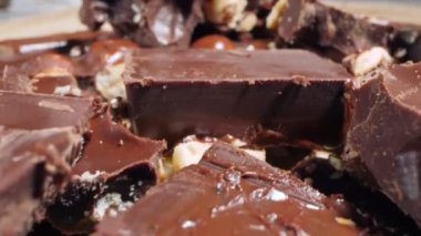 extreme close-up detailed broken pieces of bittersweet chocolate with whole hazelnuts