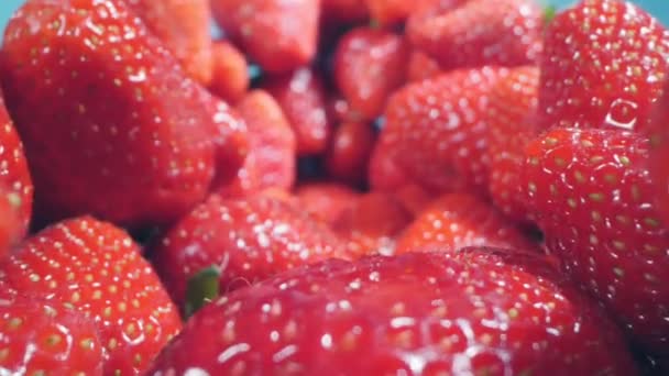 Food background. extremely close up detailed bunch of strawberries on a blue background — Vídeo de Stock