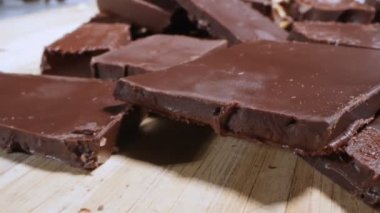 extreme close-up detailed broken pieces of bittersweet chocolate with whole hazelnuts.