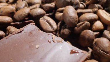 Extreme close-up of detailed coffee beans and bittersweet chocolate chunks with whole hazelnuts.