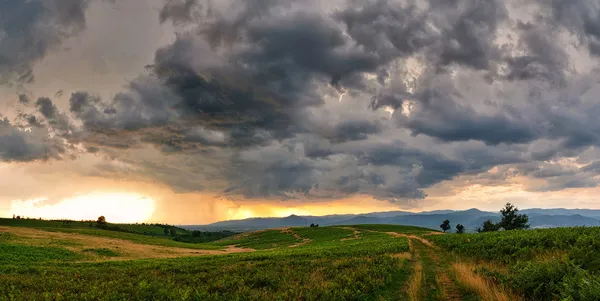 日光と左に向かって起こっているパスで劇的な嵐のシーン. — ストック写真