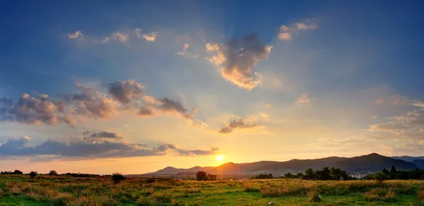 Цветной осенний закат с солнечными лучами, окрашивающими облака. — стоковое фото