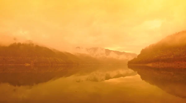 Sunrise on a misty morning over a big accumulation lake. — Stock Photo, Image