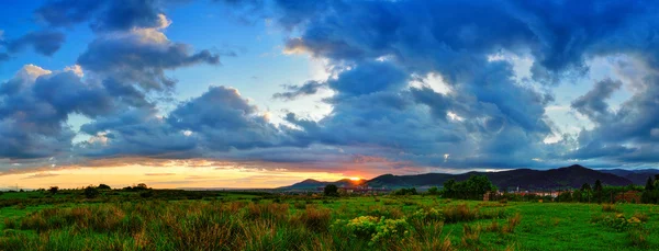 Farbenfroher Sommersonnenuntergang nach einem regnerischen Tag. Sonne färbt die Wolken. — Stockfoto