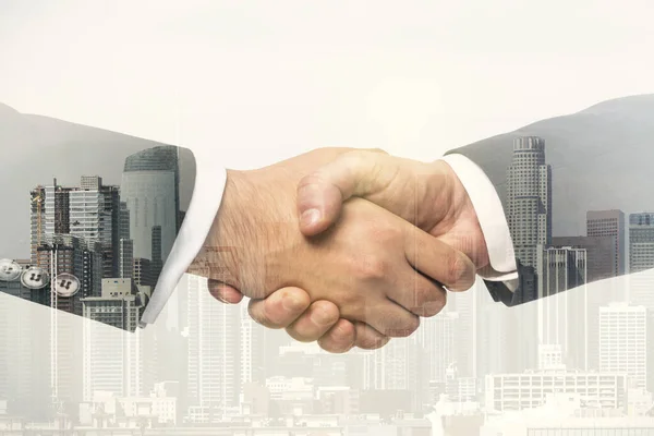 Két üzletember kettős expozíciós kézfogása irodaépületek hátteréről, együttműködési és együttműködési koncepciójáról — Stock Fotó