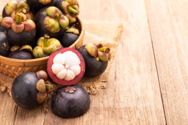 Ahşap masa arkasındaki mangosteen yığınını kapat. Gıda ve sağlık konsepti