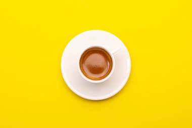 Sarı bardakta beyaz bardakta kahve.