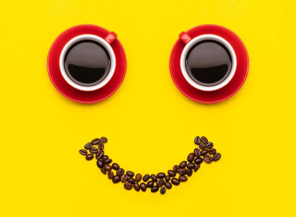两杯咖啡和咖啡豆 面带微笑的概念 顶部的黄色背景 早上快乐的概念 — 图库照片