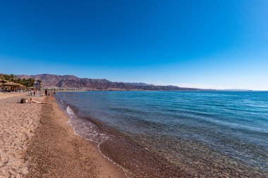 Eilat, İsrail 09 Şubat 2022 Ürdün dağlarıyla birlikte İsrail 'in güneyindeki Eilat' ta eğlenen insanlar 