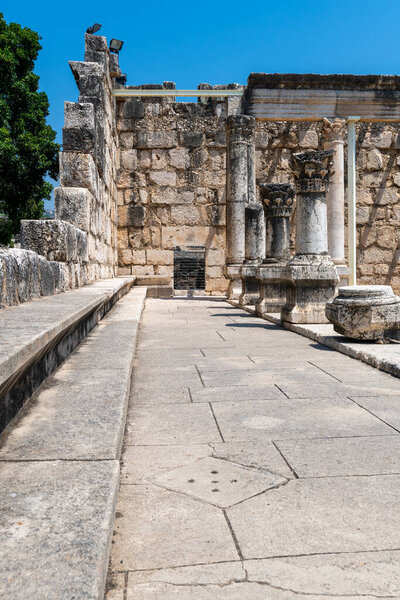 Гостиная зона, состоящая из каменных скамеек в руинах Белой синагоги, где Иисус проповедовал в Капернауме, Кфар-Нахуме, Капарнауме, рядом с Галилейским морем в Израиле