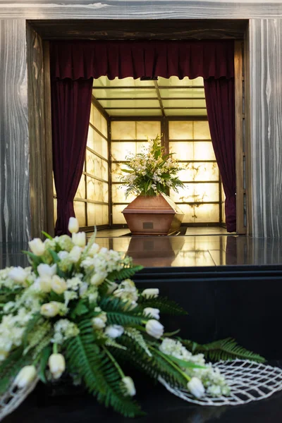 Дерев'яна труна з похоронними квітами в крематорії — стокове фото