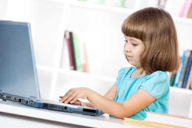 Little girl using laptop clipart