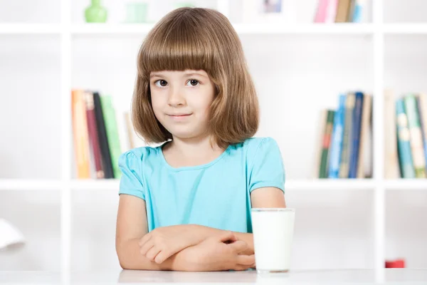 Mooi klein meisje en glas melk — Stockfoto