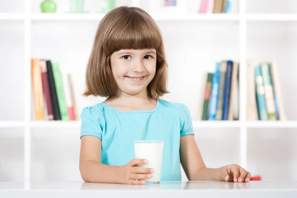 Söt liten flicka med glas mjölk — Stockfoto