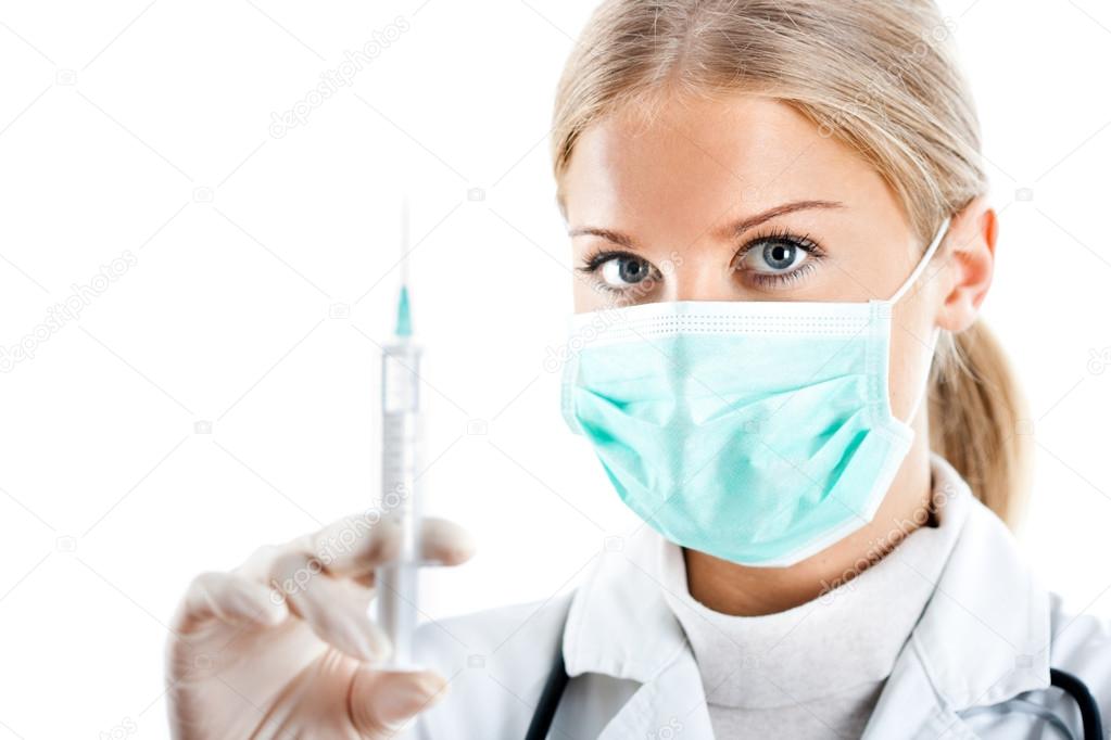 Doctor with protective mask and syringe