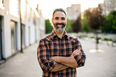 Şehir sokaklarında duran sakallı modern iş adamının portresi..