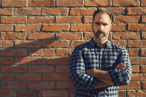 レンガの壁の屋外の前に立ってひげを生やして怒っているビジネスマンの肖像画 — ストック写真