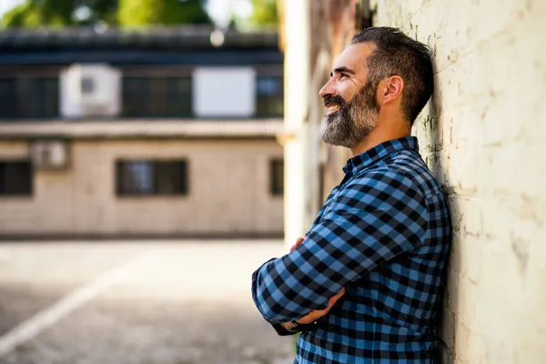 レンガの壁の屋外の前に立って髭を生やした現代ビジネスマンの肖像画 — ストック写真