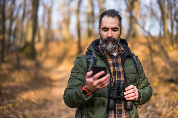 自然の中で時間を過ごしながら携帯電話を使用してハイカーのイメージ — ストック写真