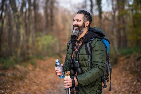 ハイキング中に水のボトルを保持する男のイメージ — ストック写真