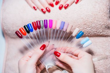 Manikürcünün manikürcünün renk paletini gösteren resmini kapat. Paletin bir kısmına odaklan.