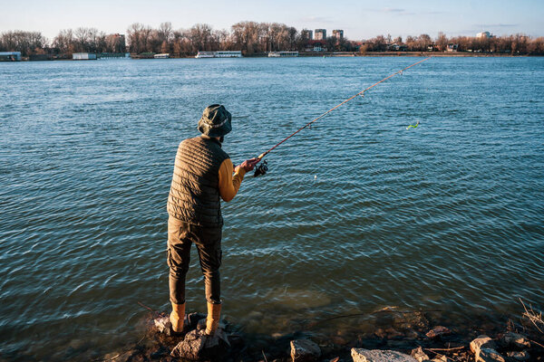 Man enjoys fishing at the river.