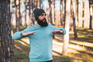 Sakallı bir adam doğada egzersiz yapmaktan hoşlanır..