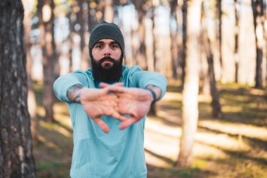 Sakallı bir adam doğada egzersiz yapmaktan hoşlanır..