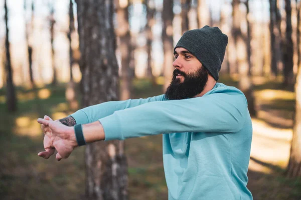 Man with beard enjoys exercising in nature.