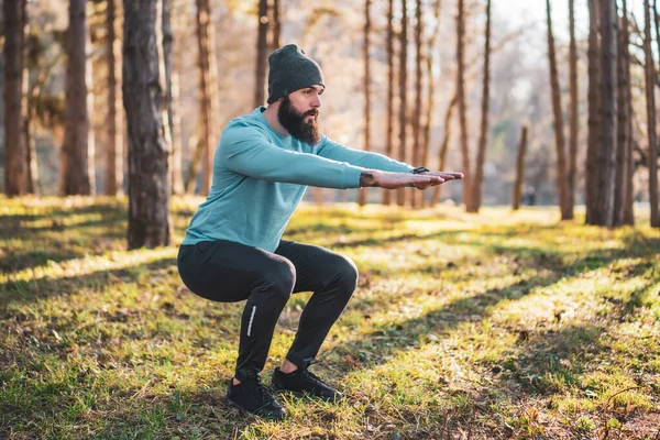 Man with beard enjoys exercising in nature.