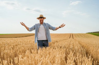 Mutlu çiftçi buğday tarlasında duruyor..