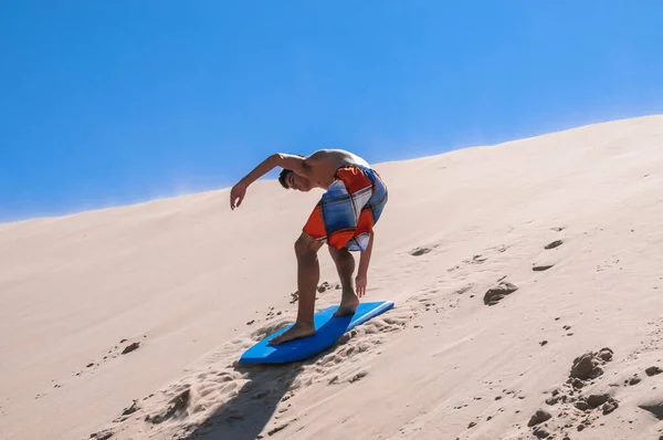 Tarifa 'nın kum tepelerinde kayan beyaz bir genç adam.