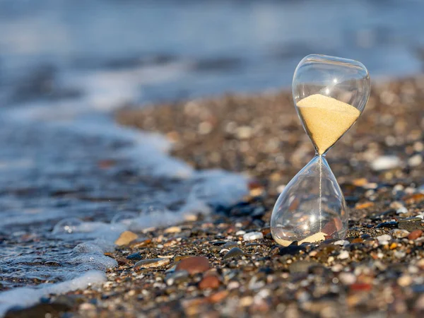 Hourglass on the beach at the seashore