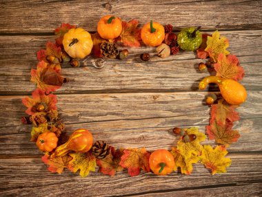 Sonbahar kompozisyonu. Balkabakları, ahşap arka planda kurumuş yapraklar. Sonbahar Cadılar Bayramı konsepti. Boşluğu kopyala