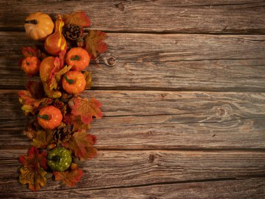 Sonbahar kompozisyonu. Balkabakları, ahşap arka planda kurumuş yapraklar. Sonbahar Cadılar Bayramı konsepti. Boşluğu kopyala