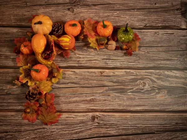Sonbahar kompozisyonu. Balkabakları, ahşap arka planda kurumuş yapraklar. Sonbahar Cadılar Bayramı konsepti. Boşluğu kopyala