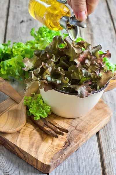 Olijfolie pourling op groene salade — Stok fotoğraf