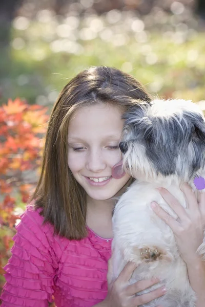 Dog licking young girls cheek — Stock Photo, Image