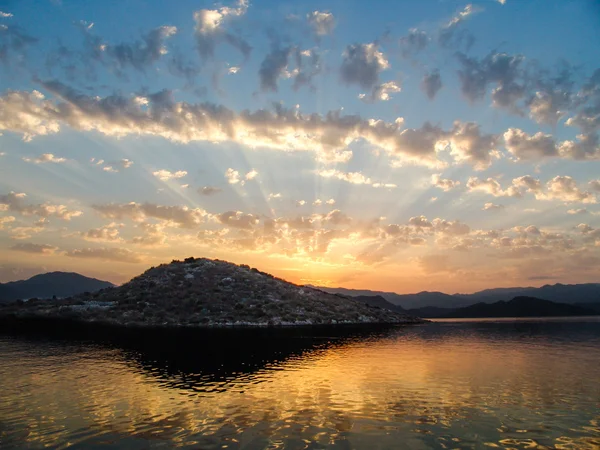 Sundset with ray of lights piercing the clouds — Stock Photo, Image