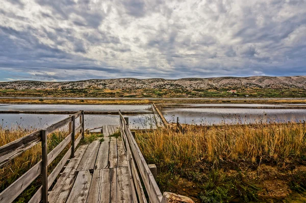 Wood boardwalk leading to a saline. HDR picture. — Stock Photo, Image