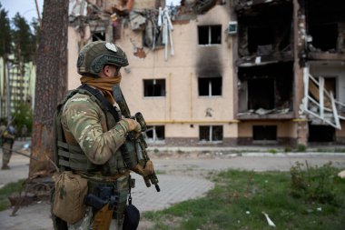 20.05.2022 Ukrayna. Irpin. Bir Ukraynalı asker Irpin 'deki Rus ordusunun bombaladığı evlere bakıyor..