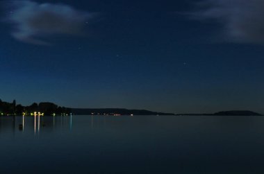 Açık bir gecede göl manzarası