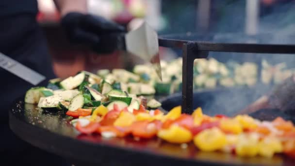 Primer plano de calabacín cortado, cebolla, pimientos rojos y amarillos asar a la parrilla profesional parrilla fumador sazonado con especias aromáticas y hierbas, proceso de preparación de verduras en parrilla barbacoa al aire libre — Vídeos de Stock